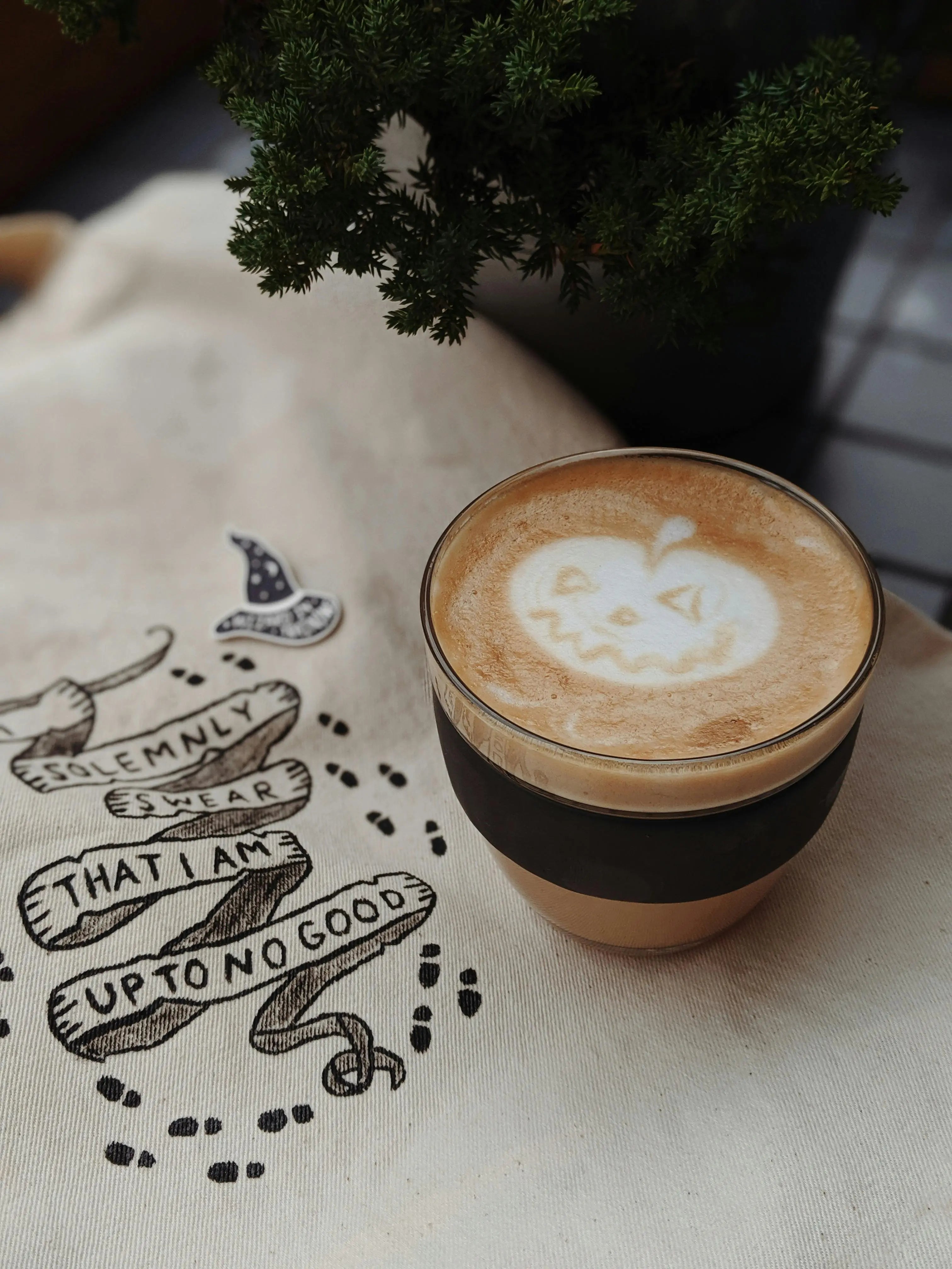 Fall Time coffee drink on artsy burlap with pumpkin coffee art in the froth