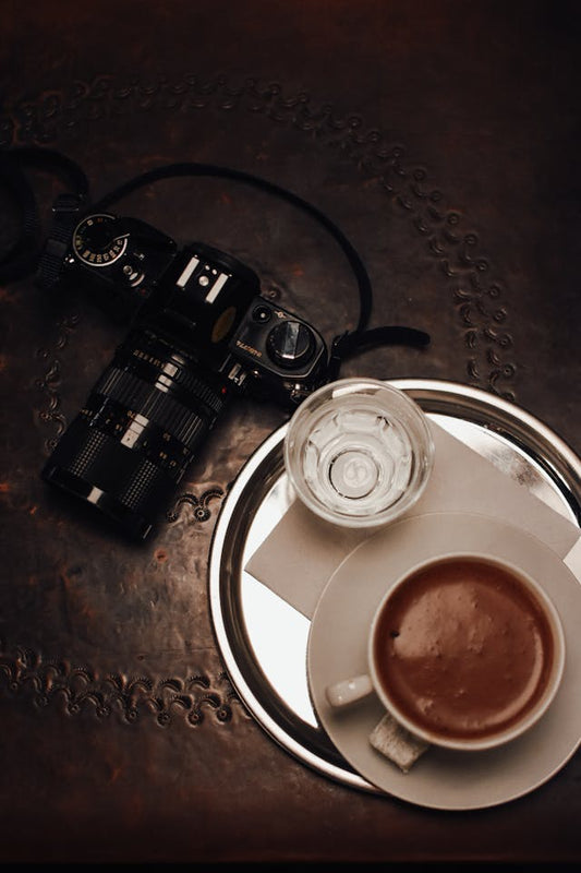 A camera and a cup of coffee noting the dark history of coffee