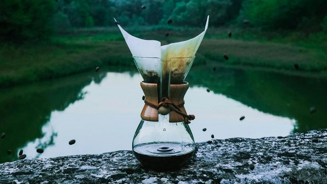 Drip coffee brewer sitting outdoors, coffee beans falling inside the filter