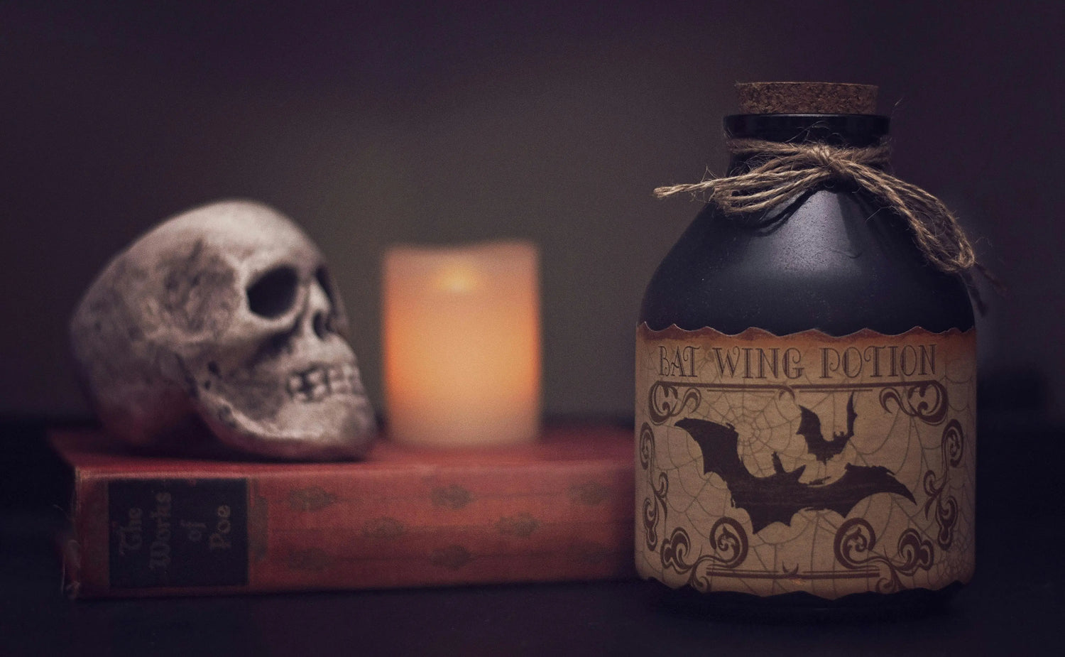 Skull on top of book with potion bottle beside it